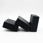 Activated charcoal soap bars on white plate