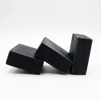 Activated charcoal soap bars on white plate