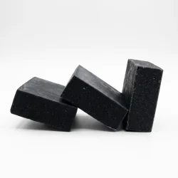 Activated charcoal soap bars on white plate
