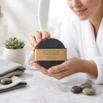 Woman holding activated charcoal face soap detox cleanser